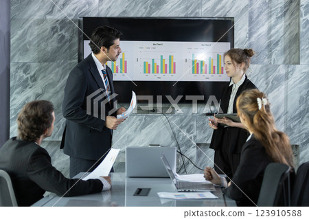 group of professionals discusses performance metrics and future goals in sleek office environment. team engages with charts displayed on screen, emphasizing collaboration. group of professionals discusses performance metrics and future goals in sleek office environment. team engages with charts displayed on screen, emphasizing collaboration. 123910588