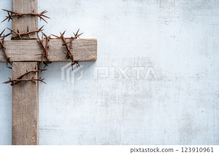 Wooden cross with barbed wire symbolizing Easter on light background 123910961