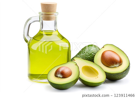 Glass jug of avocado oil with fresh avocados on white background 123911466
