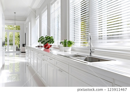 White modern kitchen with venetian blinds illuminating the countertop 123911467