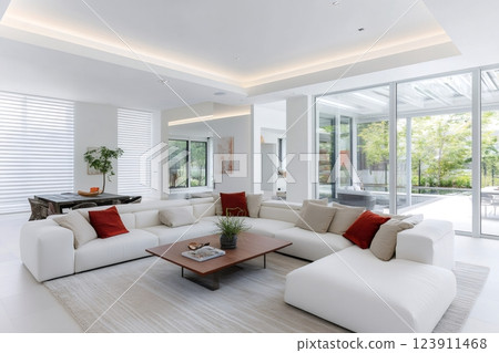 Modern white sofa illuminating spacious living room with patio view 123911468