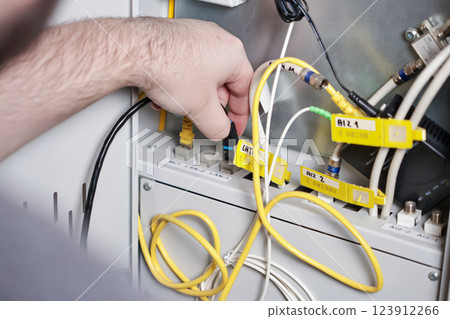 technician connecting network cables in server panel, internet and communication setup, professional technology service 123912266