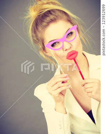 Happy elegant woman holding carnival accessoies on stick Happy elegant woman holding carnival accessoies on stick 123912699