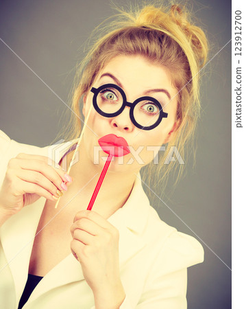 Happy elegant woman holding carnival accessoies on stick Happy elegant woman holding carnival accessoies on stick 123912700