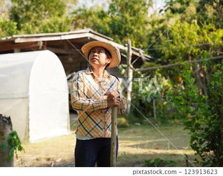 Asian adult woman working outdoors in summer garden. 123913623