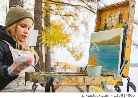 Young artist painting autumn scenery during cold weather 123914006