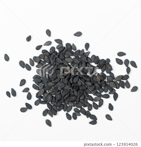 Black sesame seeds scattered on a white background macro top view Black sesame seeds scattered on a white background macro top view 123914026