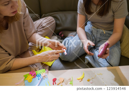 Girl using glue gun to make Easter decorations. 123914546