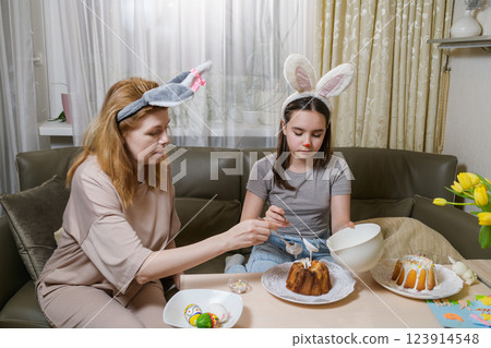 Mother and daughter decorating Easter cakes together. Mother and daughter decorating Easter cakes together. 123914548