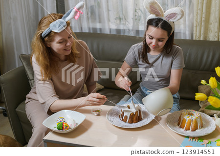 Mother and daughter decorating Easter cakes together. Mother and daughter decorating Easter cakes together. 123914551