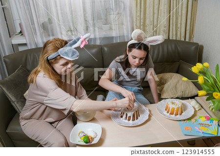 Mother and daughter decorating Easter cakes together. 123914555