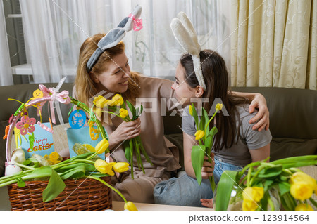Mother and daughter celebrating Easter with yellow tulips. Mother and daughter celebrating Easter with yellow tulips. 123914564