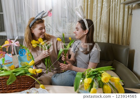 Mother and daughter celebrating Easter with yellow tulips. 123914565