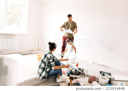 Woman with her husband and child are sitting on mattress among building materials 123914646