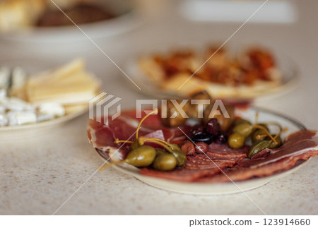 Close-up of plates with various delicious snacks on a white marble table. 123914660
