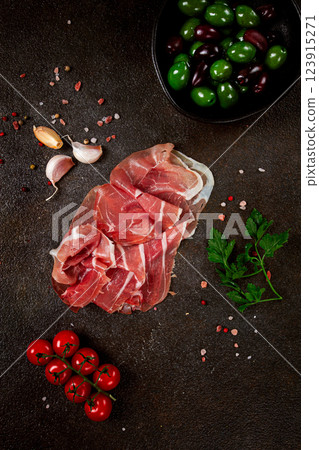 Sliced ham, on a dark background, with cherry tomatoes, and green giant olives, top view, no people, Sliced ham, on a dark background, with cherry tomatoes, and green giant olives, top view, no people, 123915271