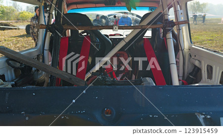 Rear view of the interior of the SUV with racing seats and safety equipment. The vehicle is being prepared for a race. Red racing seats, seat belts, safety cage 123915459