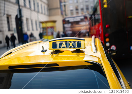 Yellow Taxi Car With A Taxi Sign On Its Roof In The Center Of The City Yellow Taxi Car With A Taxi Sign On Its Roof In The Center Of The City 123915493