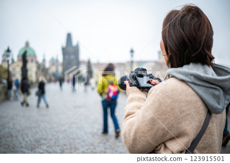 Female Photographer Taking Photos On Charles Bridge In Prague Among The Tourist Crowd Female Photographer Taking Photos On Charles Bridge In Prague Among The Tourist Crowd 123915501