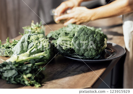 Close-up of a female hands making a green salad in the kitchen. Close-up of a female hands making a green salad in the kitchen. 123915929