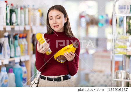 Young woman chooses floor and wood cleaner in store 123916387