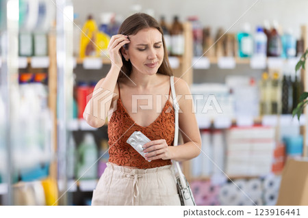 Tired young woman struggling with headache in store 123916441