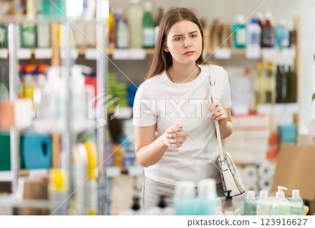 Portrait of girl shopper choosing some products in supermarket 123916627