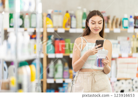 Woman scanning a package of razors on her phone Woman scanning a package of razors on her phone 123916653