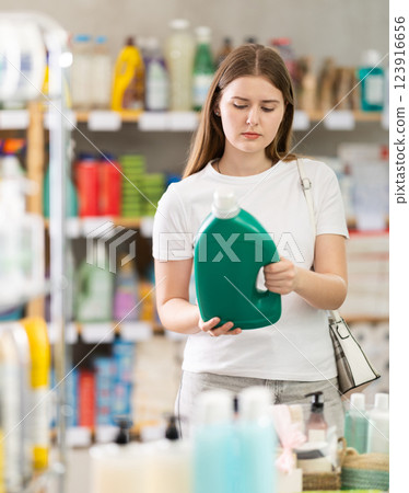 Woman consumer with household chemical products for washing indoors Woman consumer with household chemical products for washing indoors 123916656