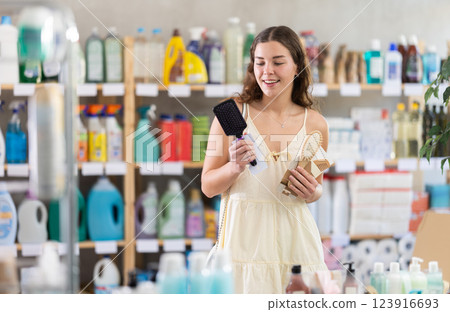 Young woman choosing hairbrush in store Young woman choosing hairbrush in store 123916693