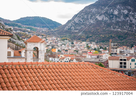 Historic bell tower with a terracotta roof in Kotor, Montenegro, standing against a dramatic mountain landscape. Concept of medieval architecture, Adriatic heritage, and scenic old town charm Historic bell tower with a terracotta roof in Kotor, Montenegro, standing against a dramatic mountain landscape. Concept of medieval architecture, Adriatic heritage, and scenic old town charm 123917004