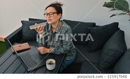 Woman Working Remotely Using Technology in an Outdoor Workspace Setting 123917048