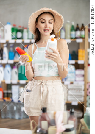 Woman view trademark sign on label, chooses eco friendly sunblock cream Woman view trademark sign on label, chooses eco friendly sunblock cream 123917085
