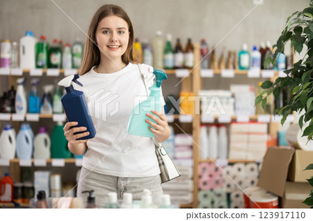 Girl looking for trademark sign on label, chooses eco friendly tile cleaner spray 123917110