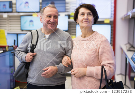 Spouses of mature age walk through the departments of the store 123917288