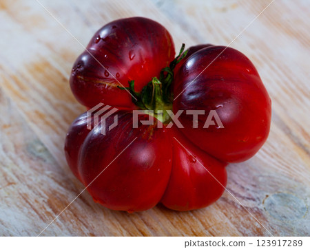 Blue tomatoes and knife on wooden cutting board 123917289
