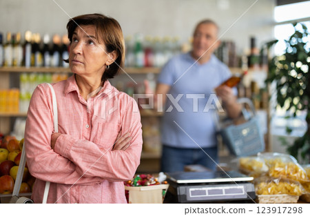 Senior husband stands behind pensioner wife and yells at companion Senior husband stands behind pensioner wife and yells at companion 123917298