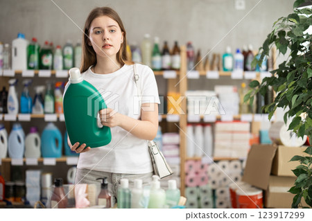 Woman consumer with household chemical products for washing indoors Woman consumer with household chemical products for washing indoors 123917299