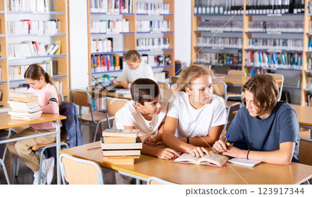 Teenagers spending time in library Teenagers spending time in library 123917344