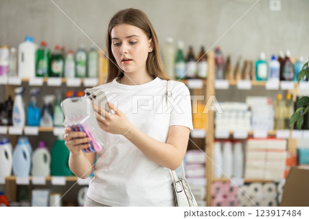 Female shopper scans QR code on label of razor for windows using smartphone 123917484