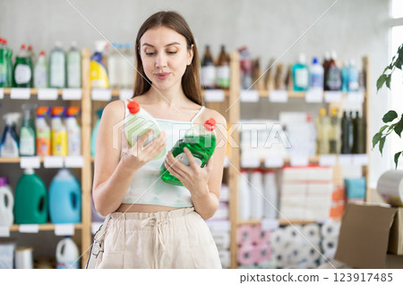 European woman chooses dishwashing detergent from different manufacturers 123917485