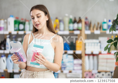 Woman looking for trademark sign on label, chooses eco friendly razor kit 123917508