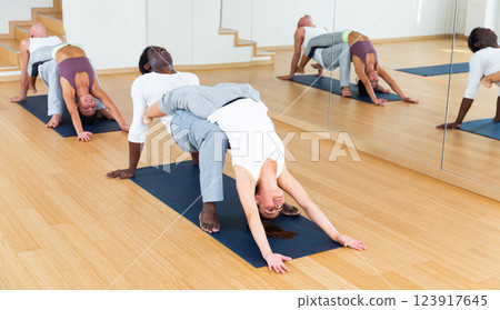 Couples yoga classes in modern fitness center 123917645
