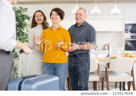 Parents and daughter joyfully greet their son and brother, who came from far away 123917649
