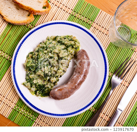 Sausage served with pearl barley and spinach 123917670