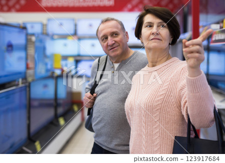 Portrait of a of mature age couple standing in the department with televisions 123917684