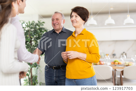 Happy girl introducing boyfriend to parents, coming family celebration 123917703