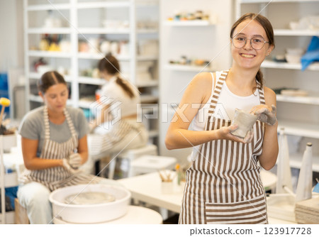 Teenage girl with handmade ceramic cup in workshop 123917728