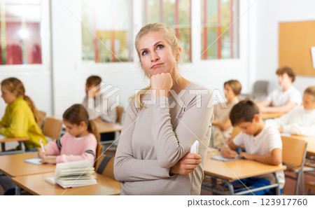 Upset female school teacher standing in classroom 123917760