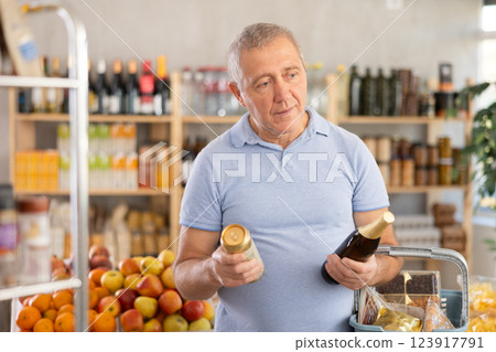 Mature man is choosing beer in grocery store 123917791
